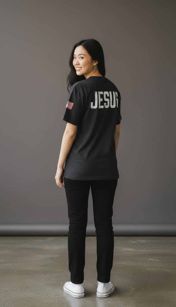 Forged By God black crewneck t-shirt with distressed JESUS back print and American flag sleeve detail on a woman.