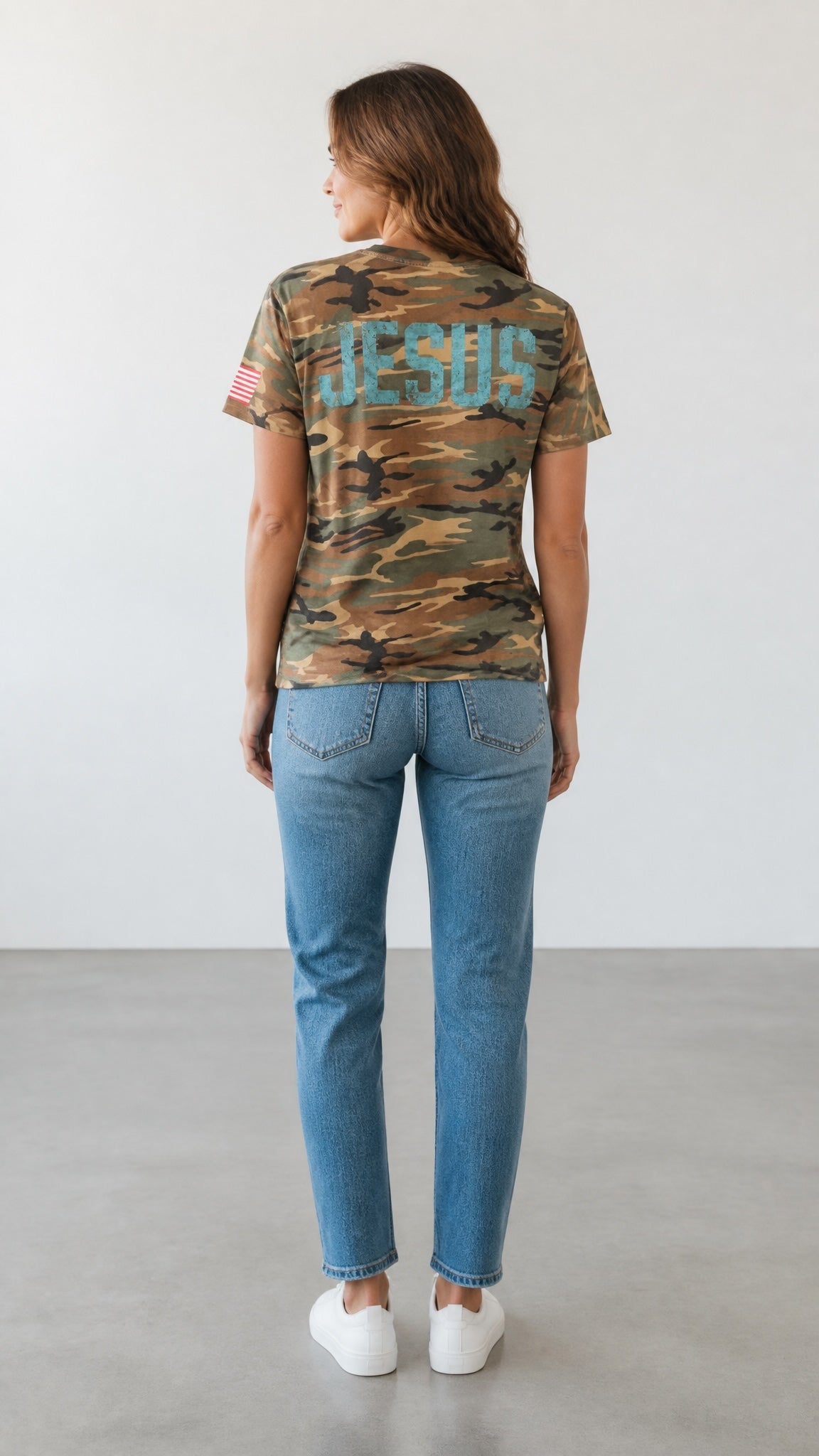 Forged By God camo crewneck t-shirt with distressed JESUS print on back and American flag sleeve detail on a woman.