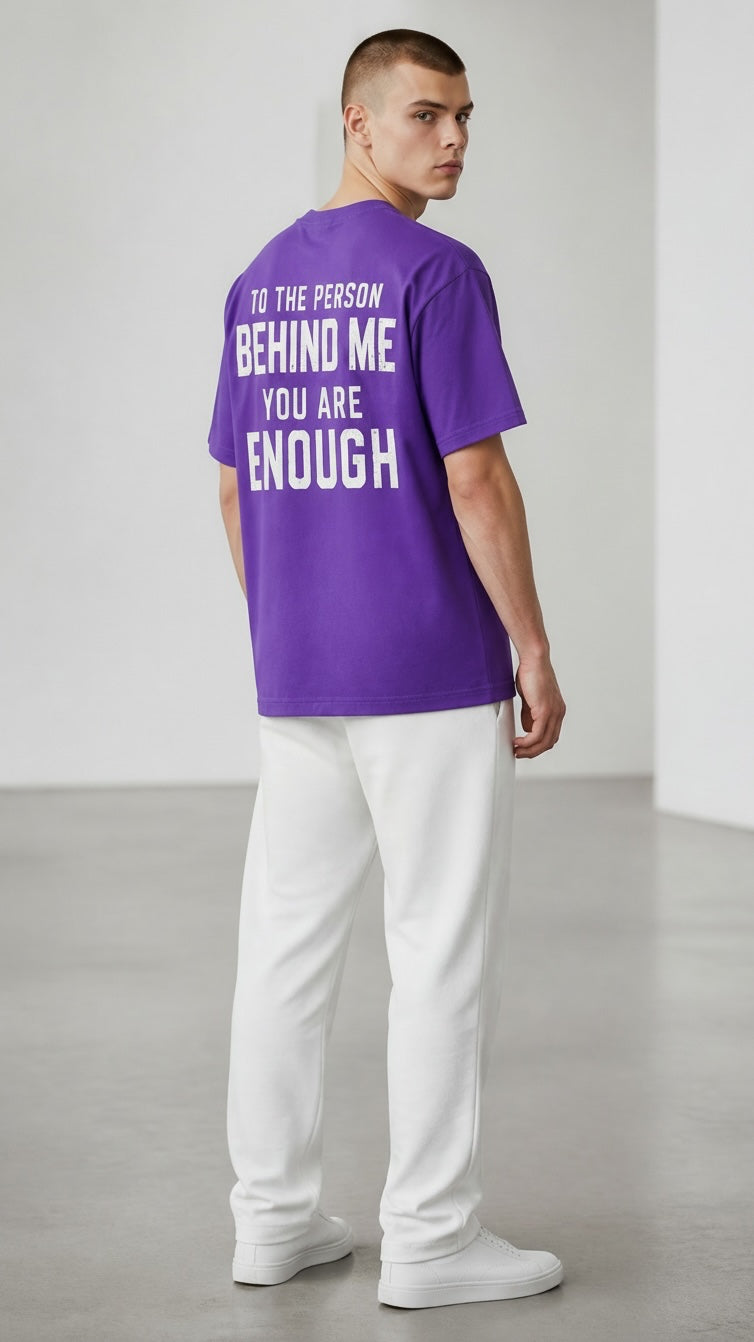 Forged By God purple crewneck t-shirt with white inspirational text on the back worn by a man in white joggers