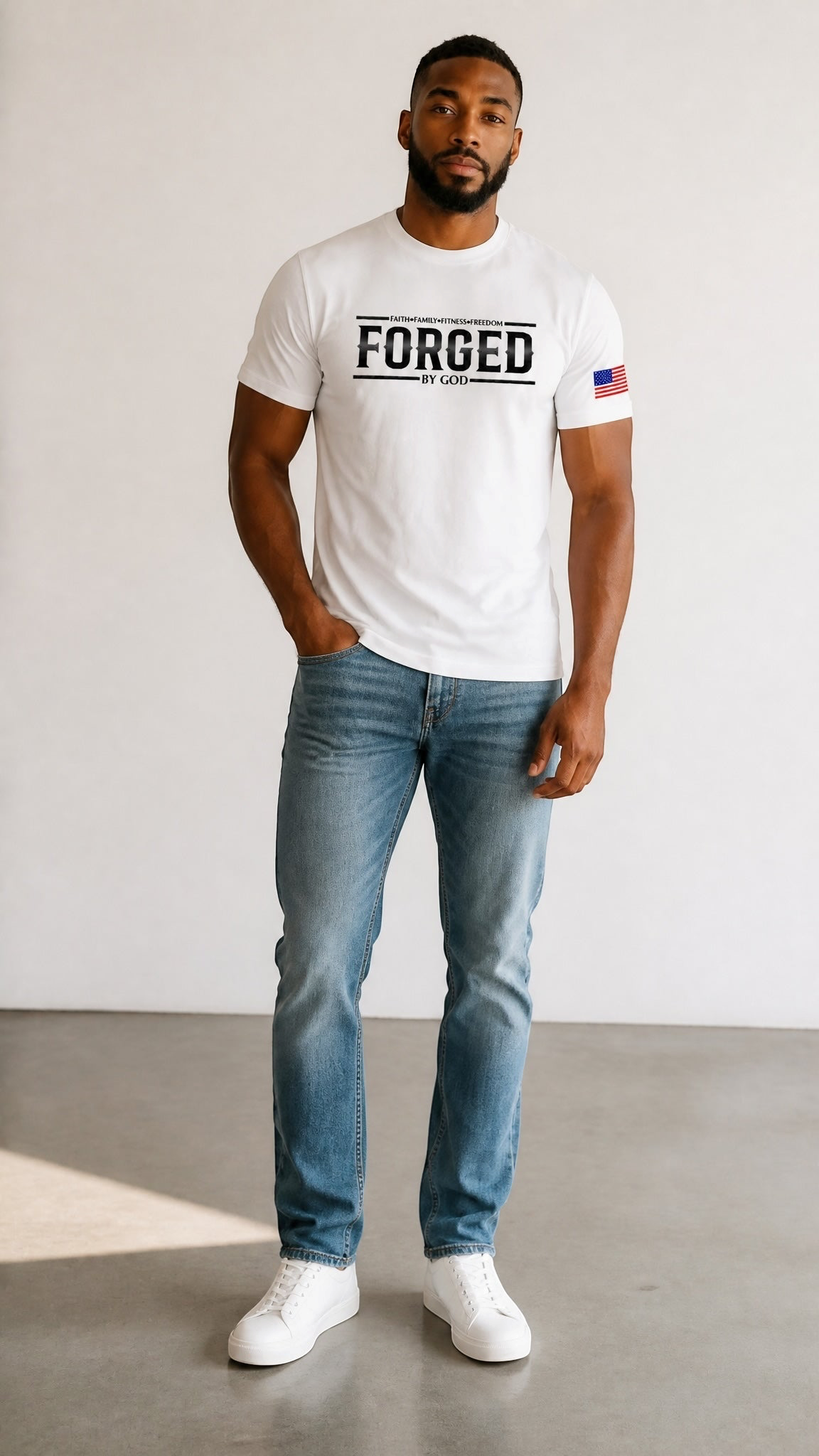 A man wearing a Forged By God white graphic t-shirt with a minimalist front logo and American flag sleeve detail.